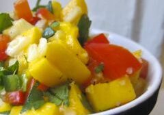 A bowl of fresh mango salsa with diced vegetables.