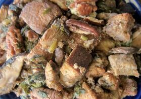 A plate of seasoned, cooked chicken pieces with herbs and spices.