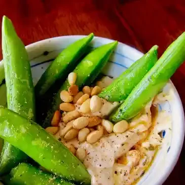 Snap peas with hummus and pine nuts.