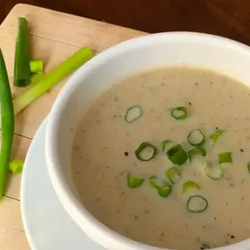 Creamy soup with green onions garnish.