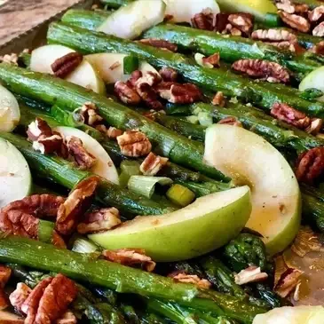 Asparagus with apples and pecans on tray.