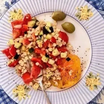 Colorful vegetable salad with olives on plate.
