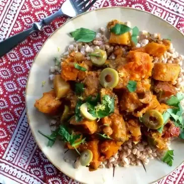 Colorful vegetarian dish with olives on plate.