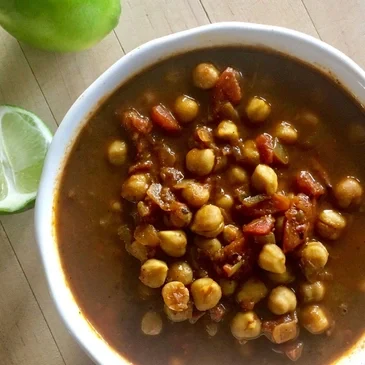 Chickpea stew with lime on table.