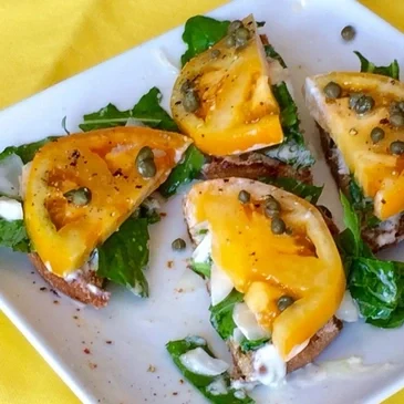 Open-faced sandwiches with tomatoes and capers.