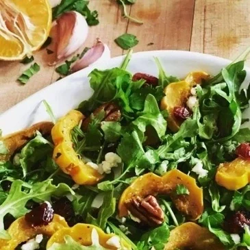 Arugula salad with squash and pecans.