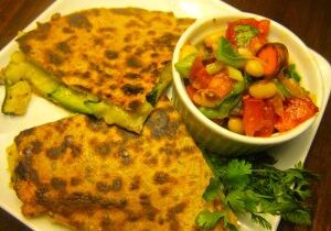 Golden-brown quesadilla served with fresh tomato and cucumber salad.