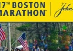Runners pass by a Boston Marathon sign during the race.