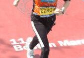 Runner crossing Boston Marathon finish line wearing bib number 72804.