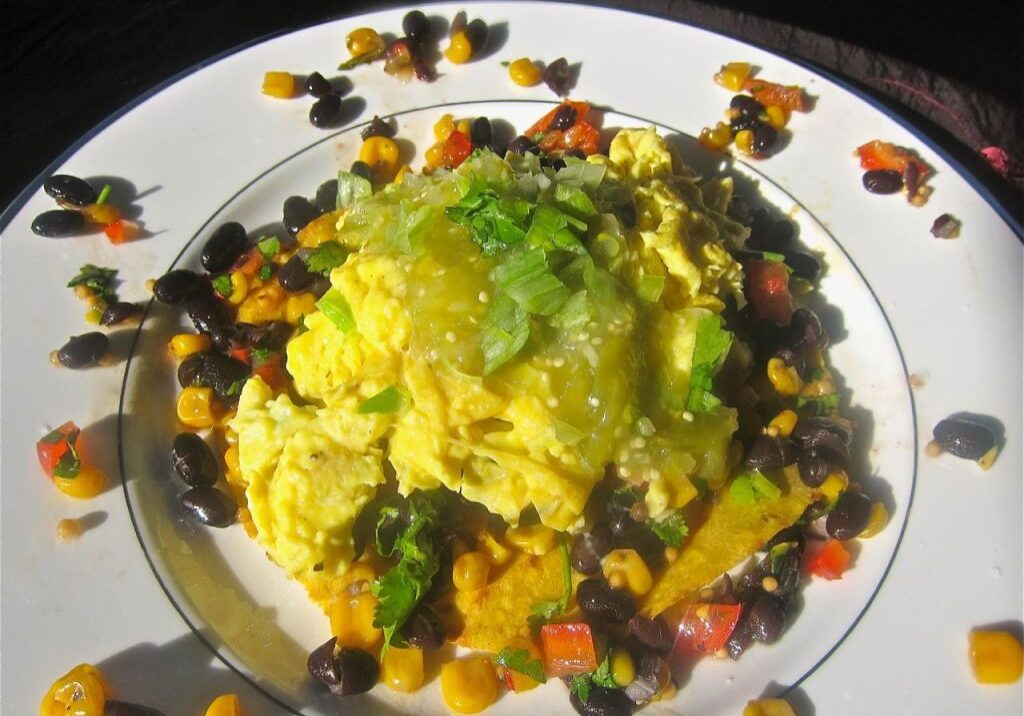 A colorful vegetable scramble topped with green garnish on a floral plate.