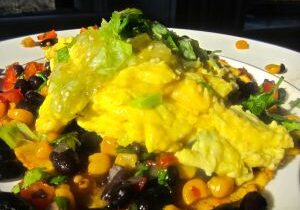Scrambled eggs served with a colorful vegetable medley.
