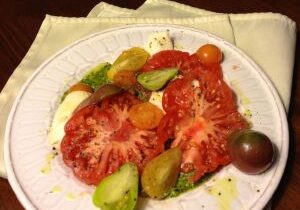 Plate with sliced heirloom tomatoes and avocado pieces.