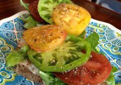 A sandwich with lettuce, tomato, and green pepper on a patterned plate.
