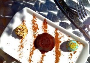 Chocolate dessert with colorful garnish on a white plate.