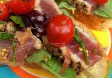Open sandwich with bacon, lettuce, and cherry tomatoes on a colorful plate.