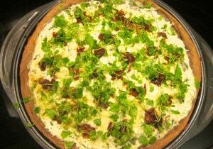 A pizza topped with green broccoli and cheese.