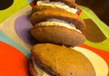 A line of whoopie pies with creamy filling on a colorful surface.